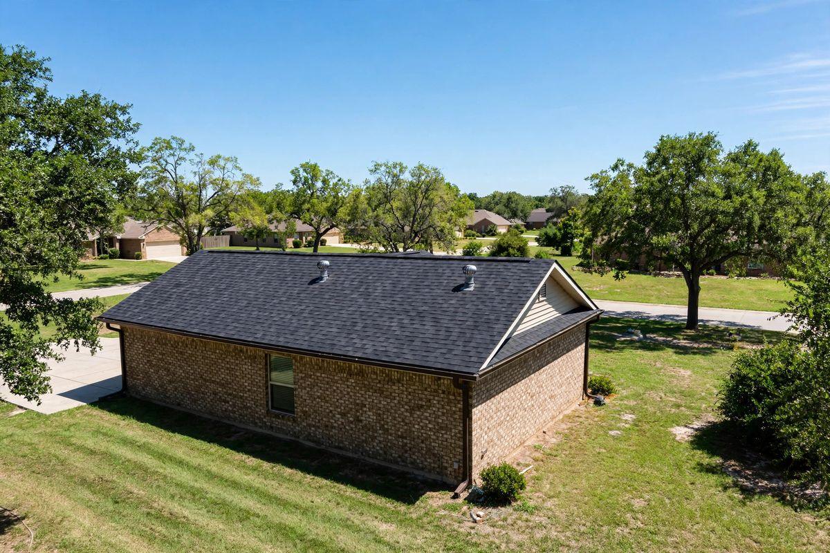 Turbine vents and a ridge vent on a shingle roof in Huntsville, Texas on a hot summer day